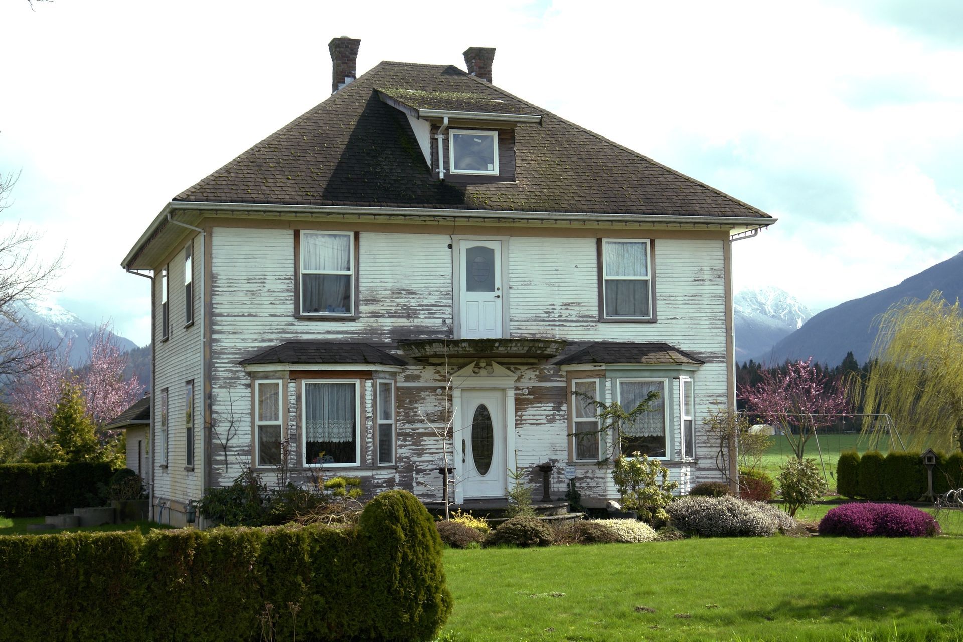 A large white house with mountains in the background