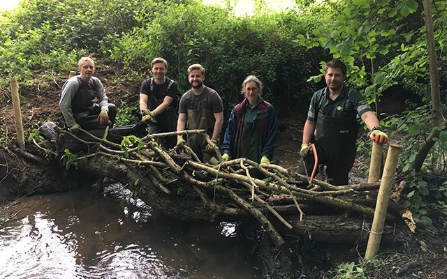 people building a leaky dam in a stream