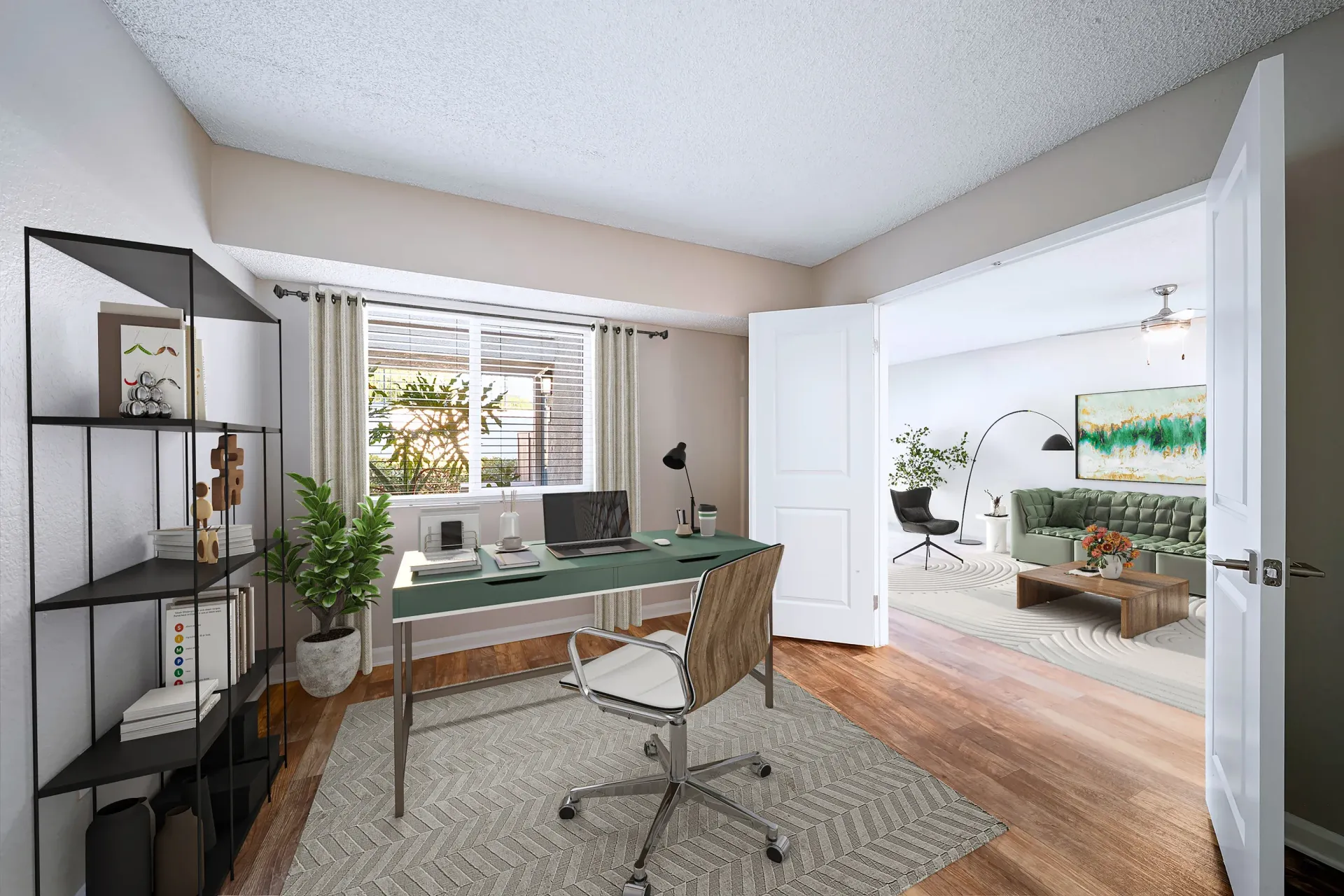 Home office corner in an apartment with desk, laptop, and view into the living room.