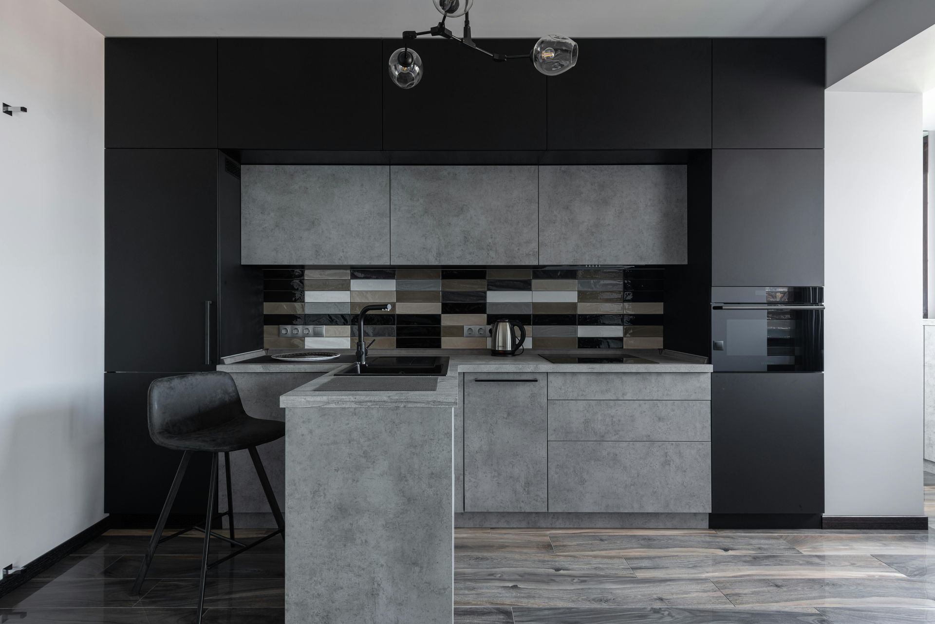 A kitchen with black cabinets and a gray counter top.