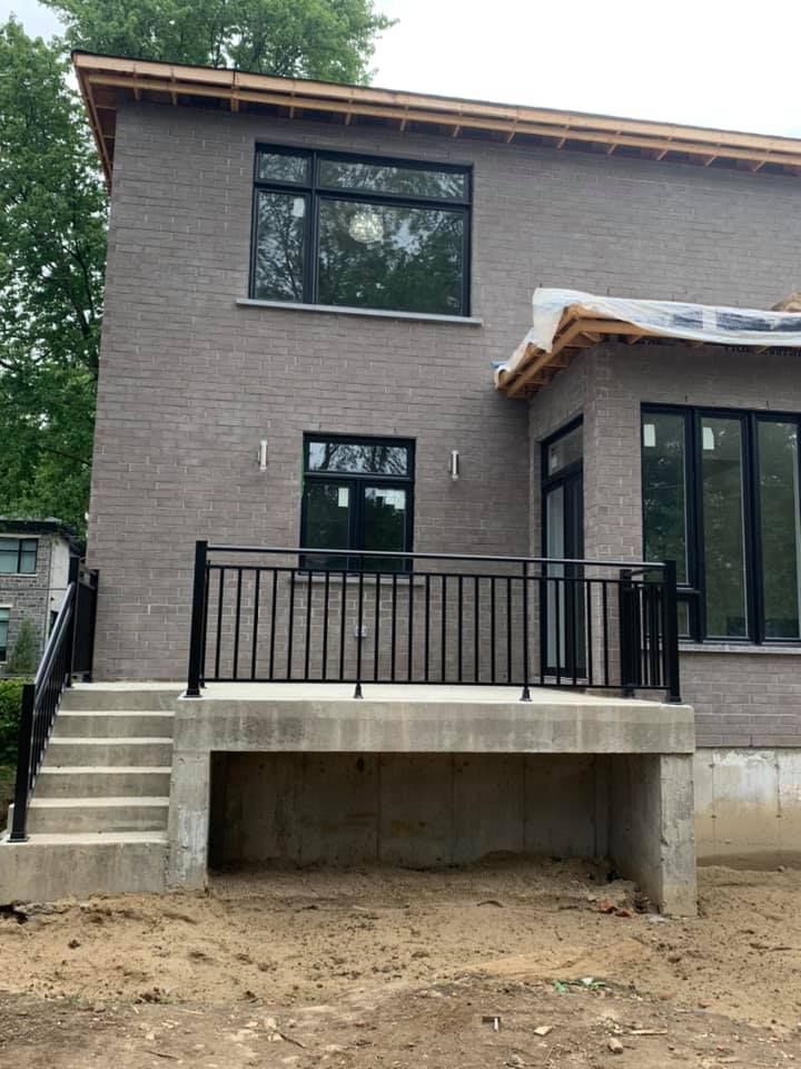 Une maison en construction avec un balcon et des escaliers