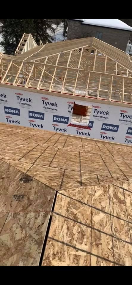 Une maison est en construction et le toit est en train d'être construit.