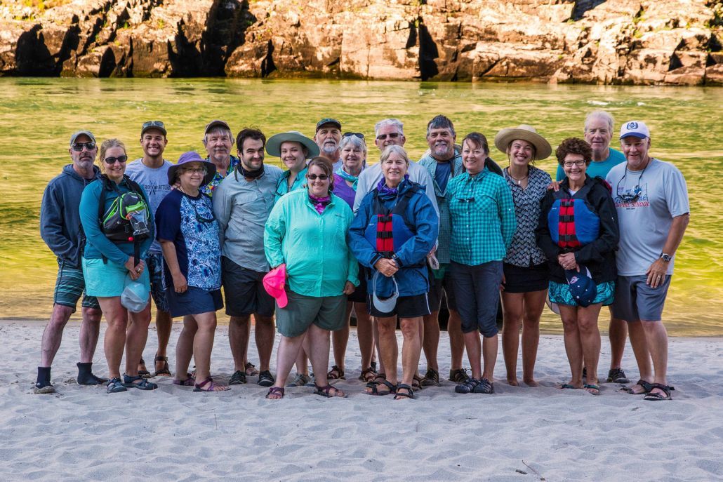 A group of people are posing for a picture on the beach.