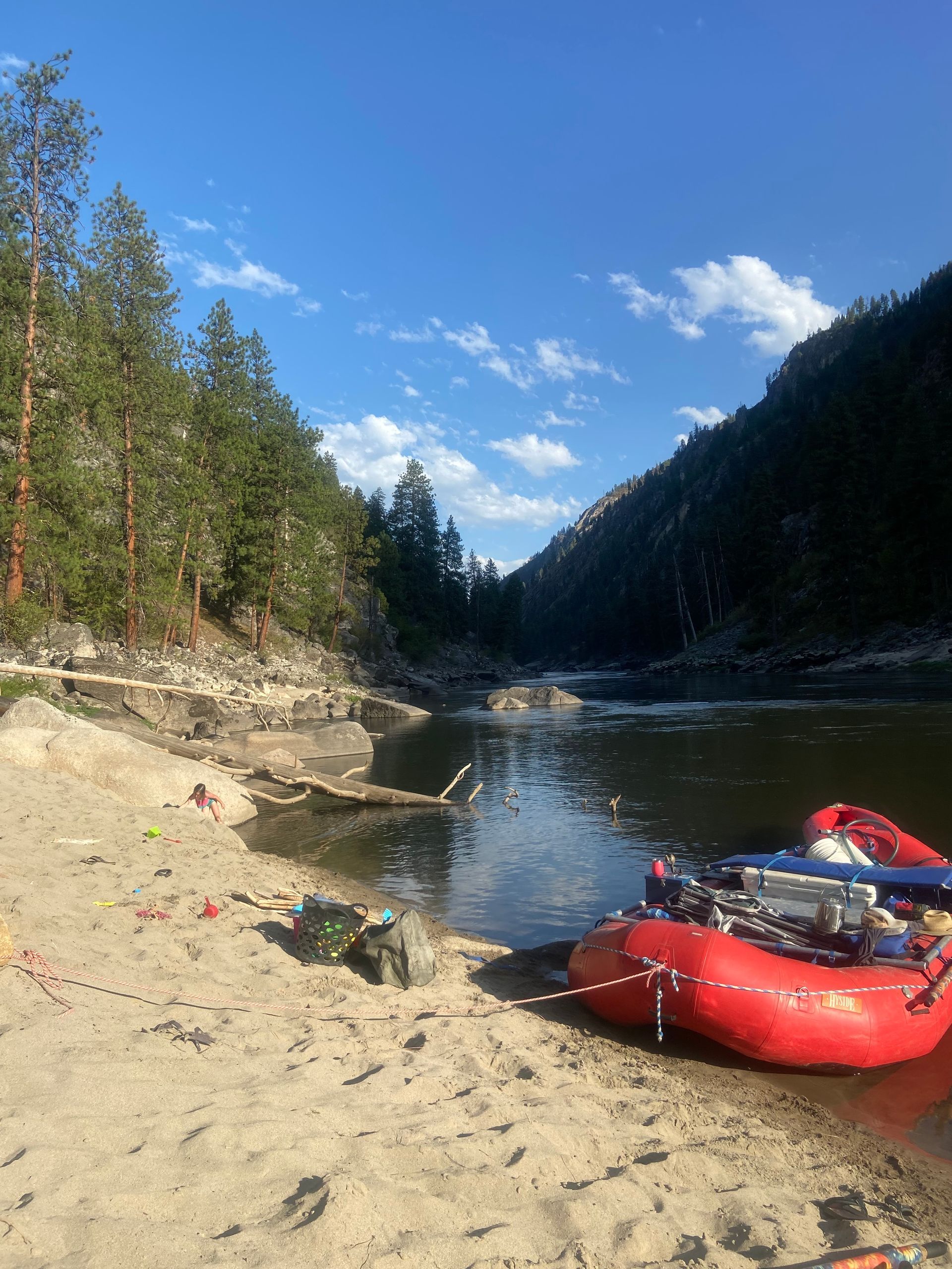 A couple of rafts are sitting on the shore of a river.