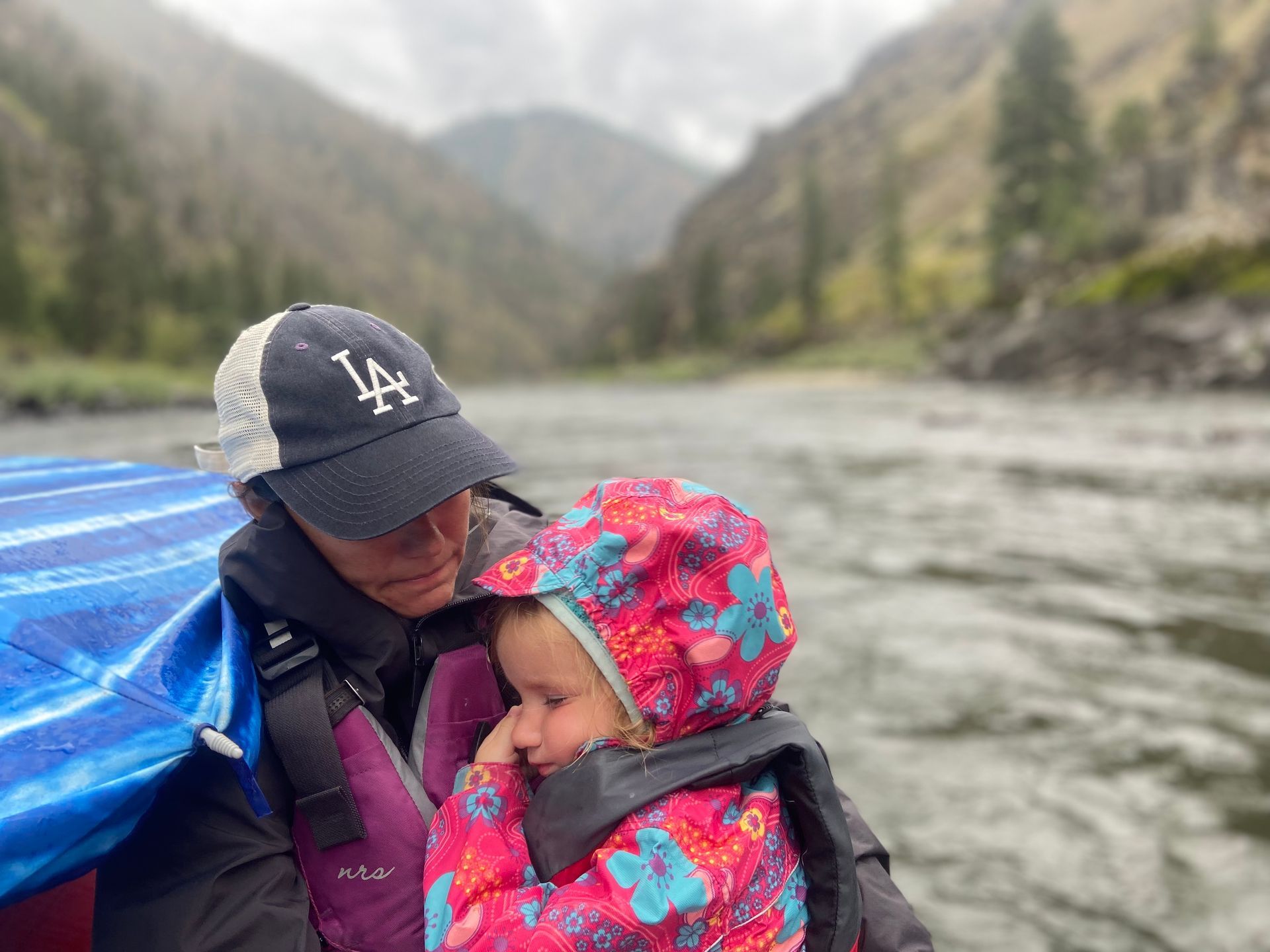A woman is holding a little girl on a boat.