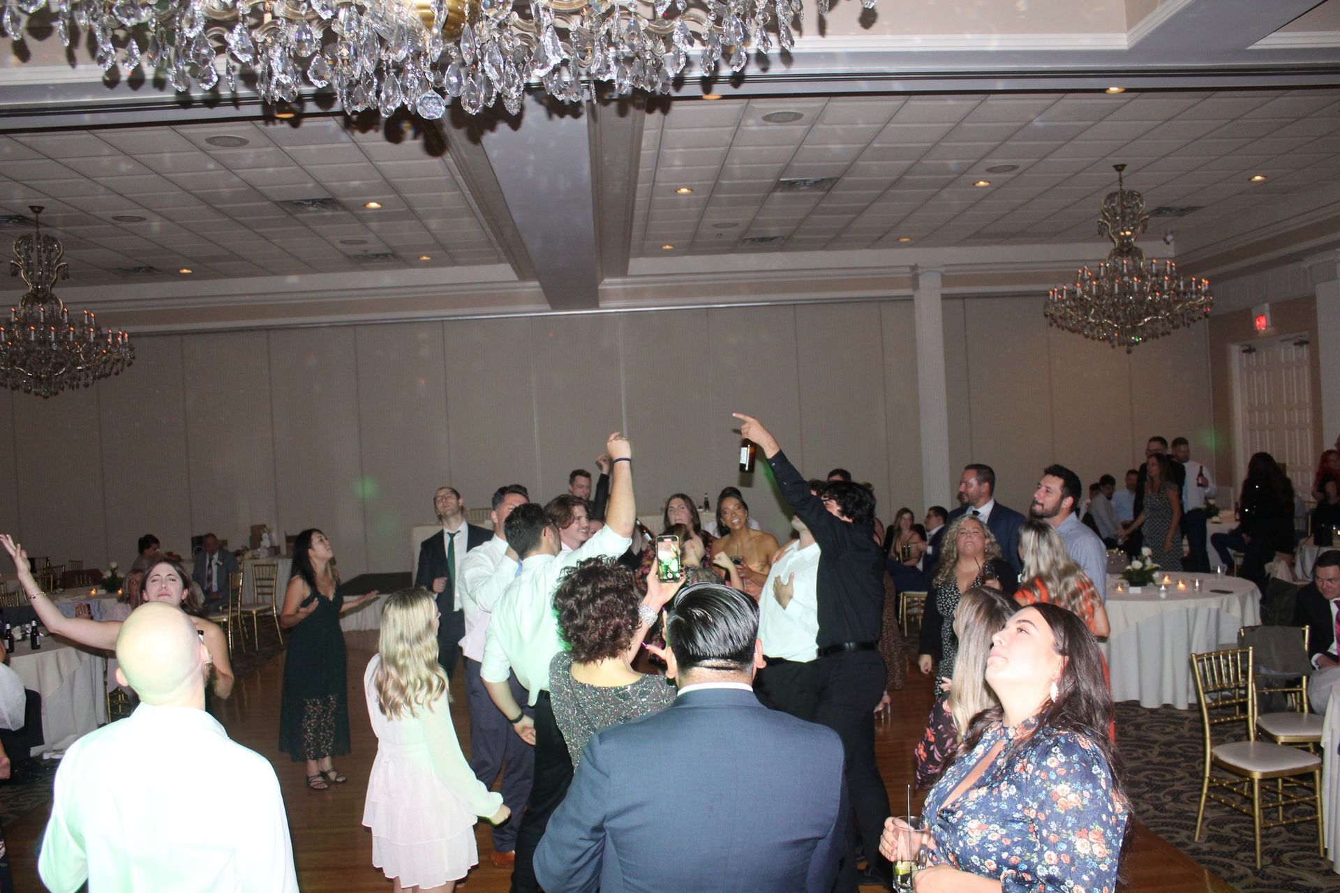 A large group of people are dancing in a large room.