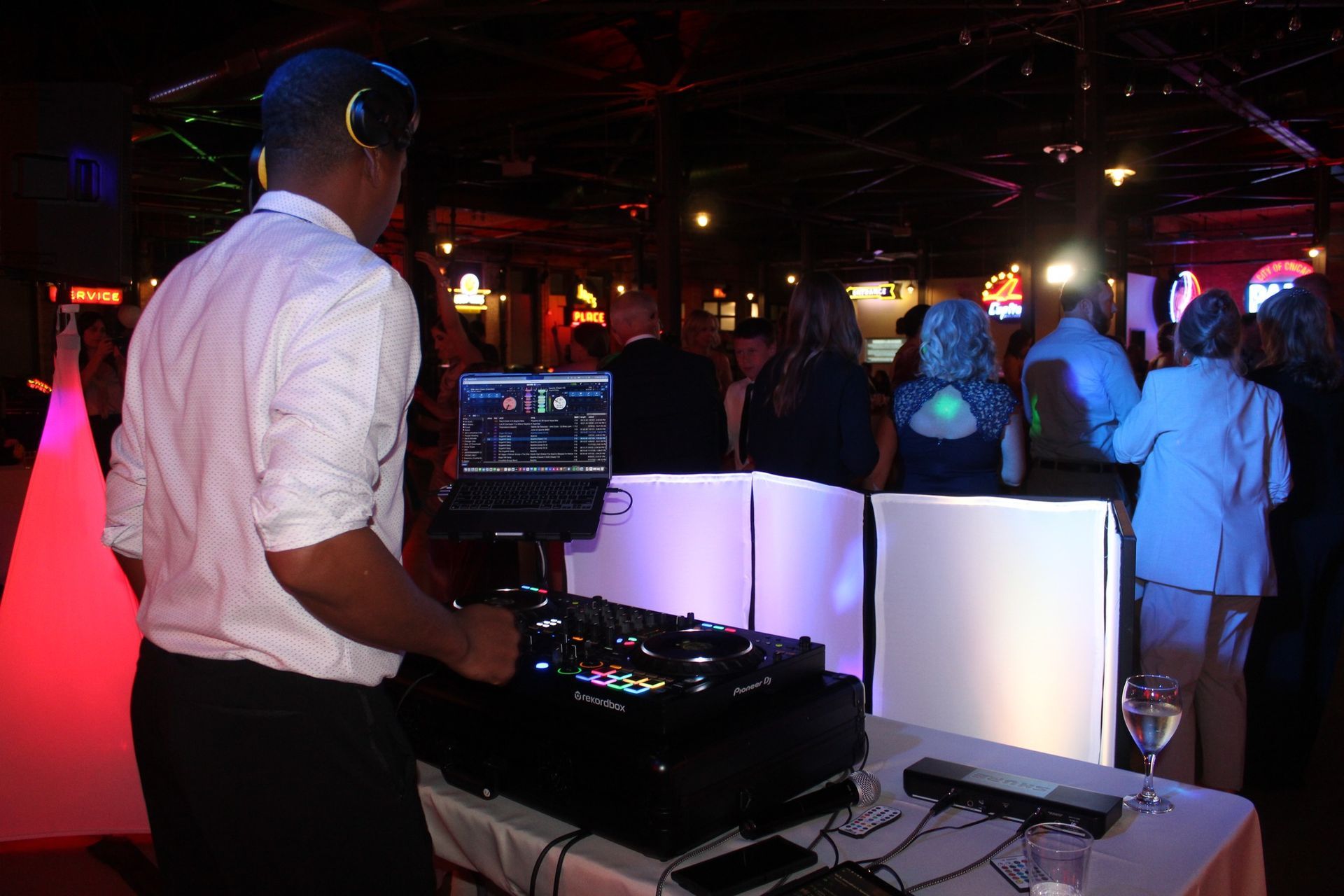 A dj is playing music at a party in front of a crowd.