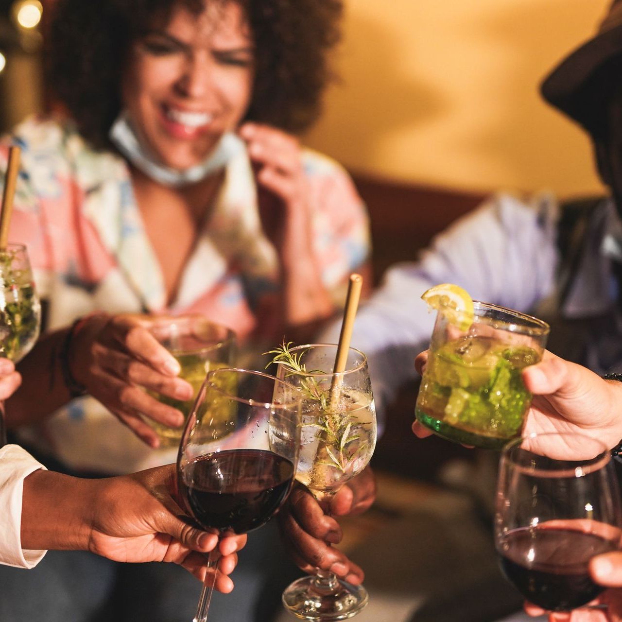 A group of people are toasting with wine glasses and drinks.