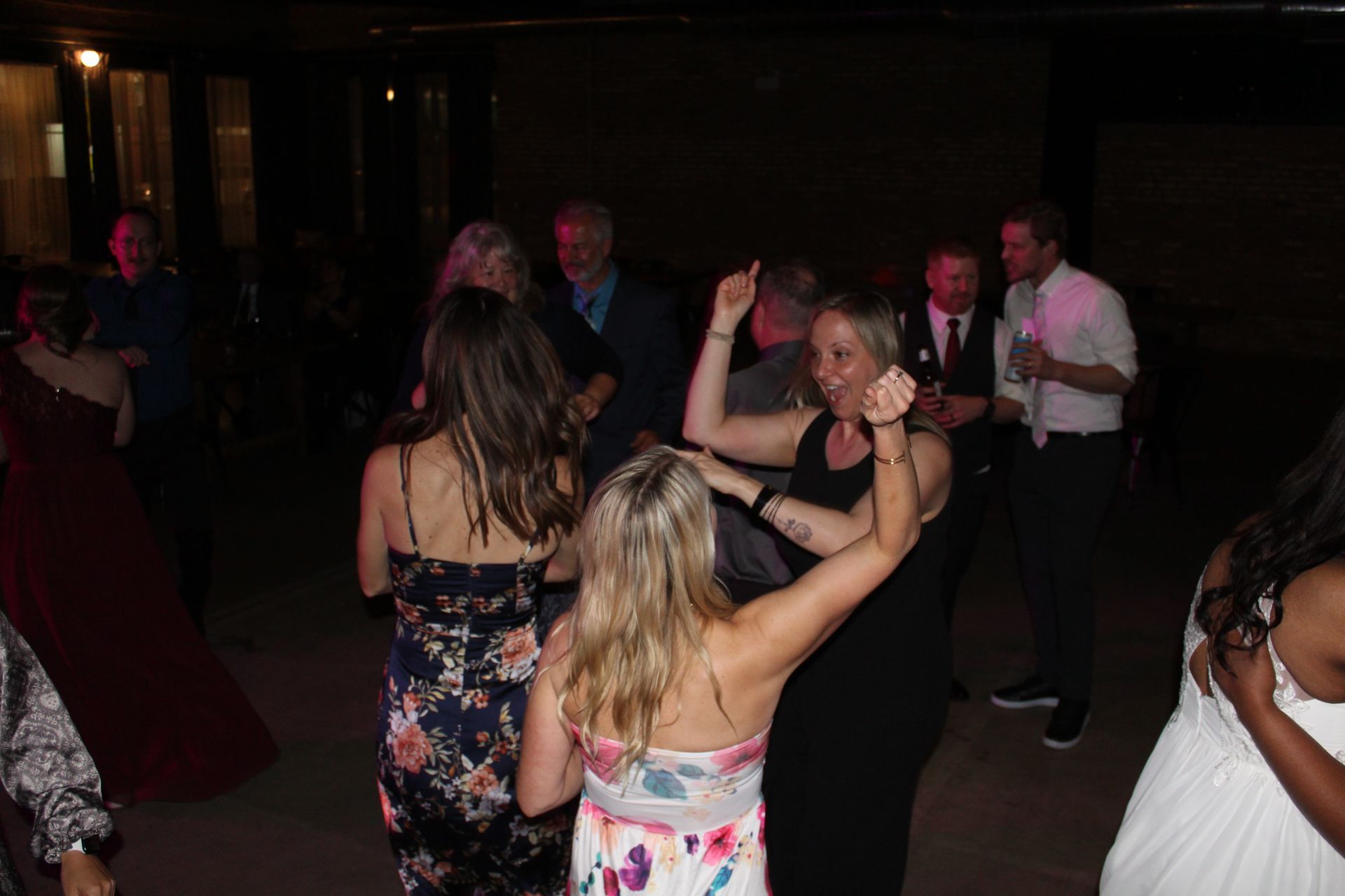 People dancing at an outdoor evening party, some with arms raised.