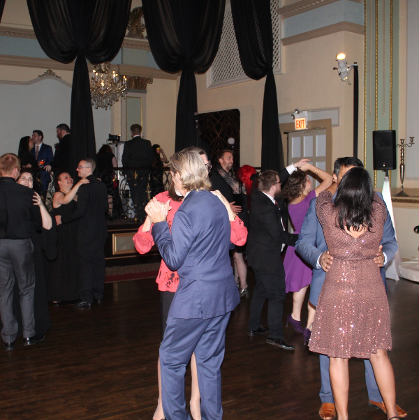 A group of people are dancing in a large room