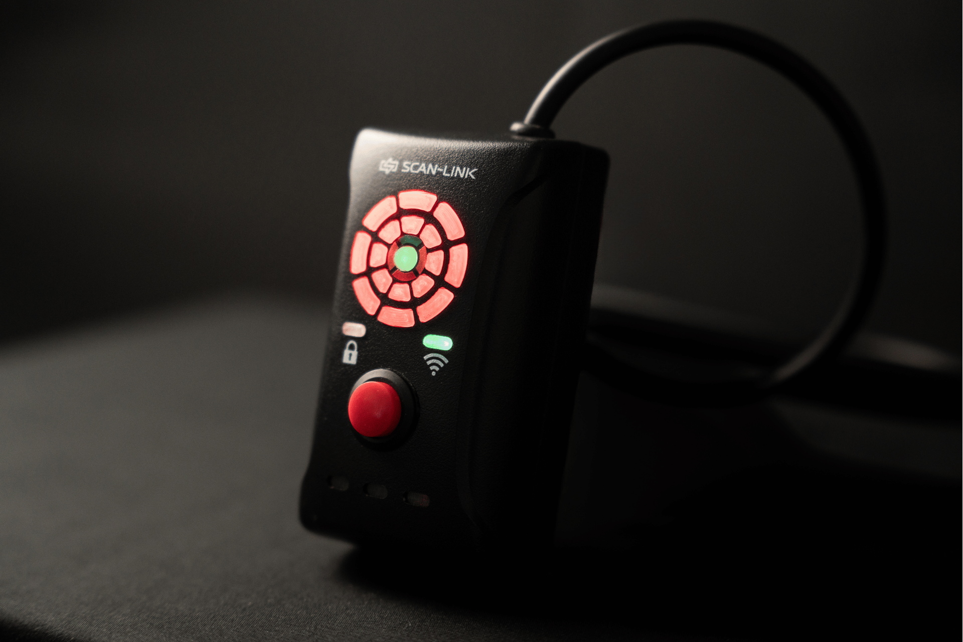 Black Scan-Link 3.0 display unit device with red and green lights and button, on a dark surface.