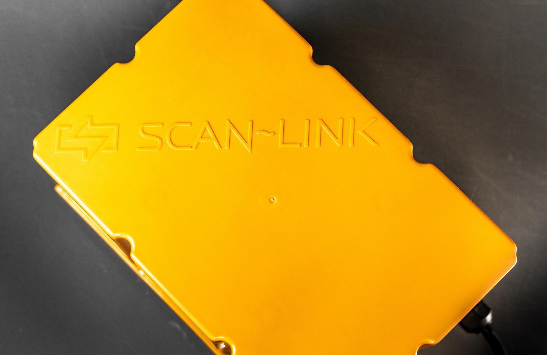 Black Scan-Link device with a red button, circular lights, and WiFi symbol on a black background.