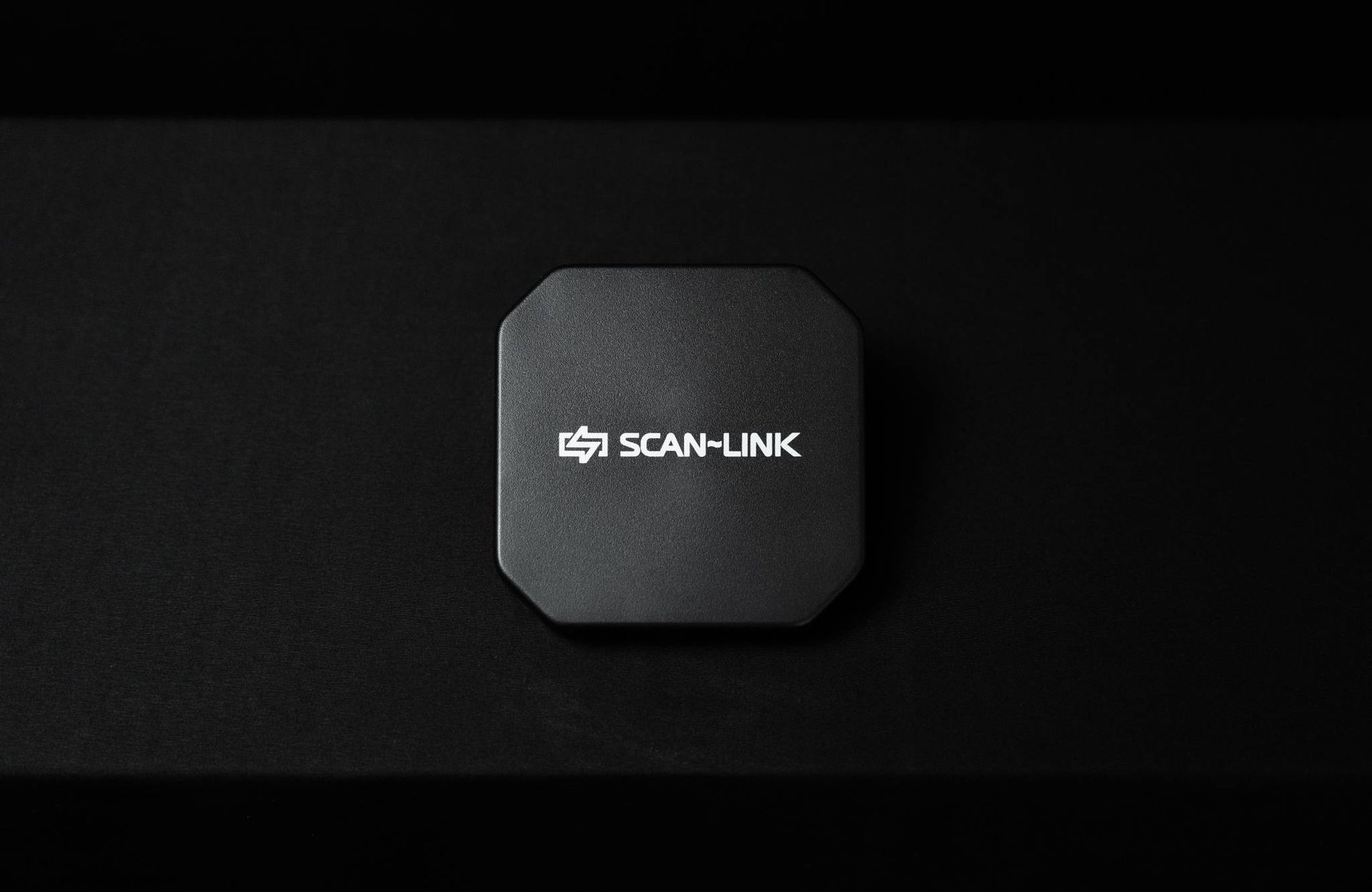 Black Scan-Link device on a dark background. The device has an octagonal shape with the Scan-Link logo.