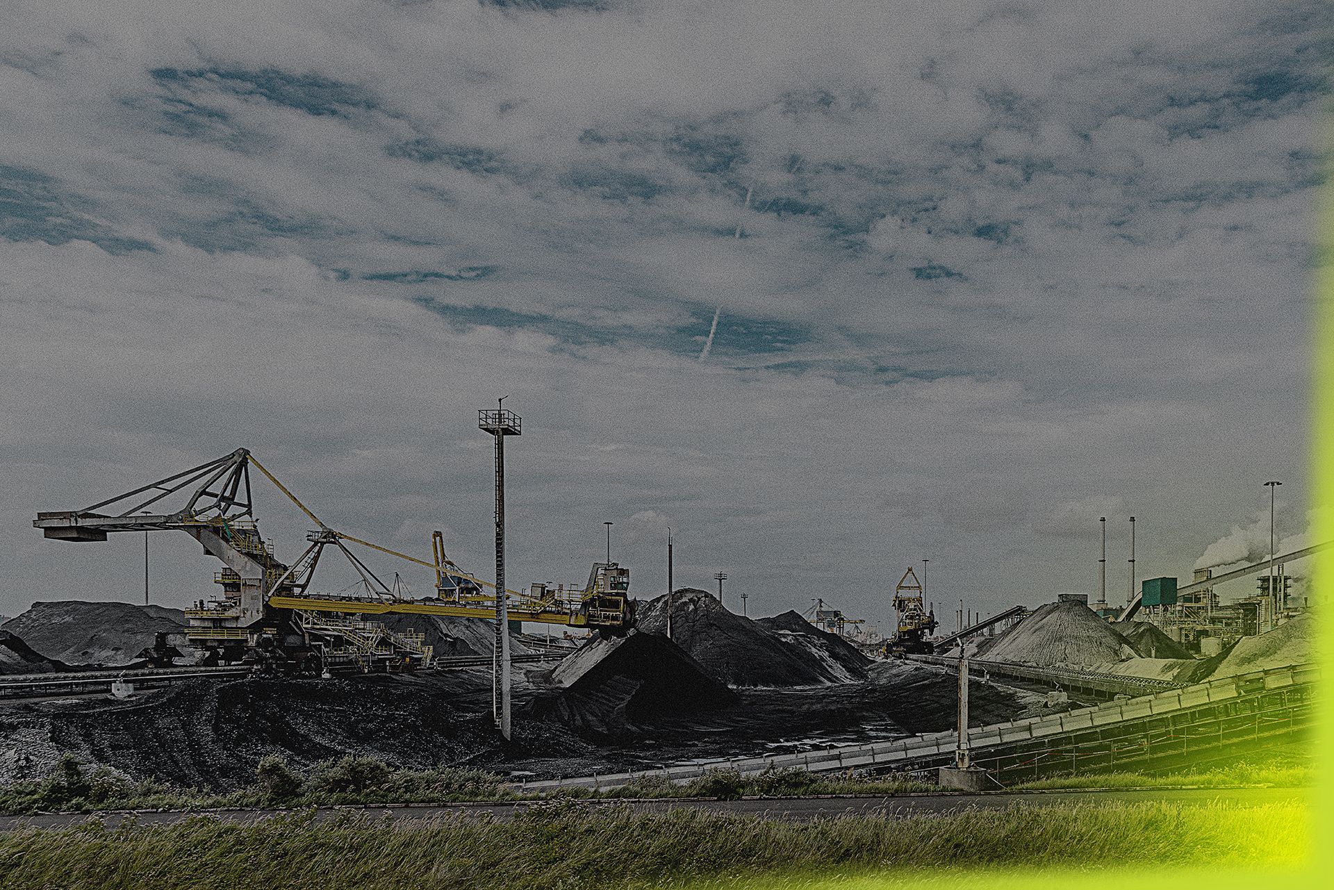 A large pile of coal is being loaded onto a conveyor belt at a coal mine.