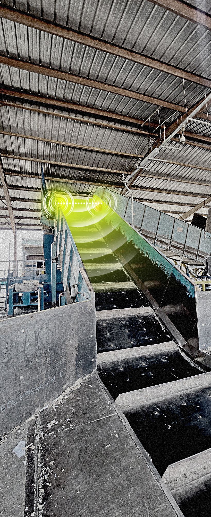 A conveyor belt in a factory with a yellow light coming out of it.