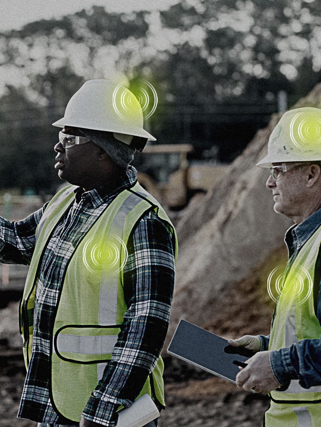 Two construction workers are standing next to each other on a construction site.