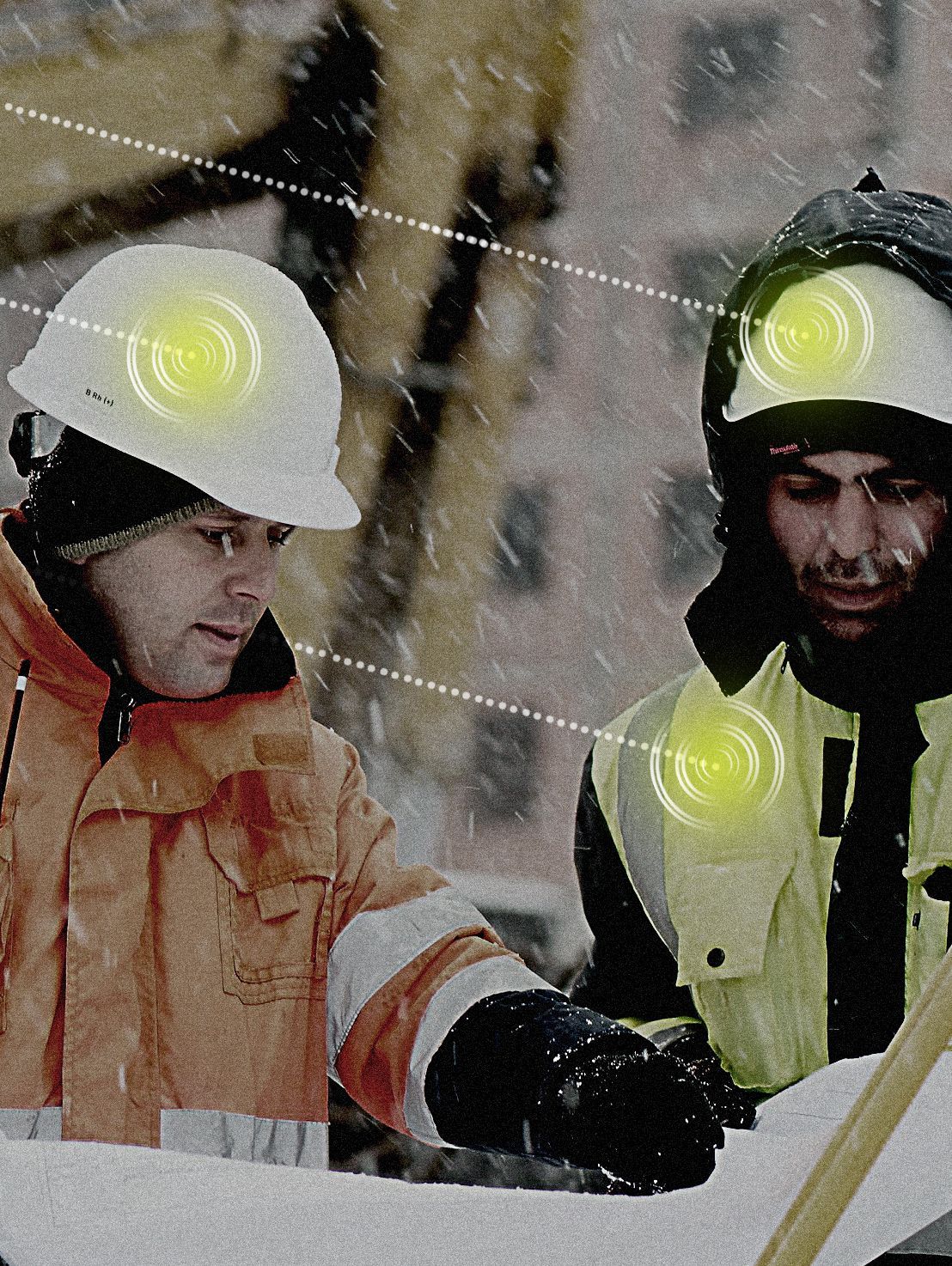 Two men wearing hard hats are looking at a blueprint