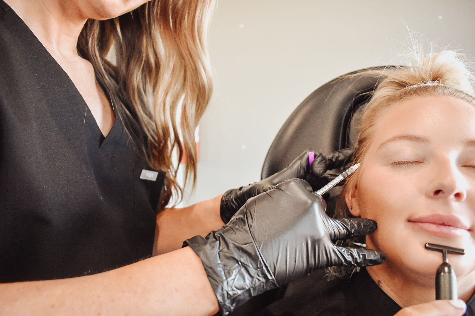 A woman is getting a botox injection in her face.