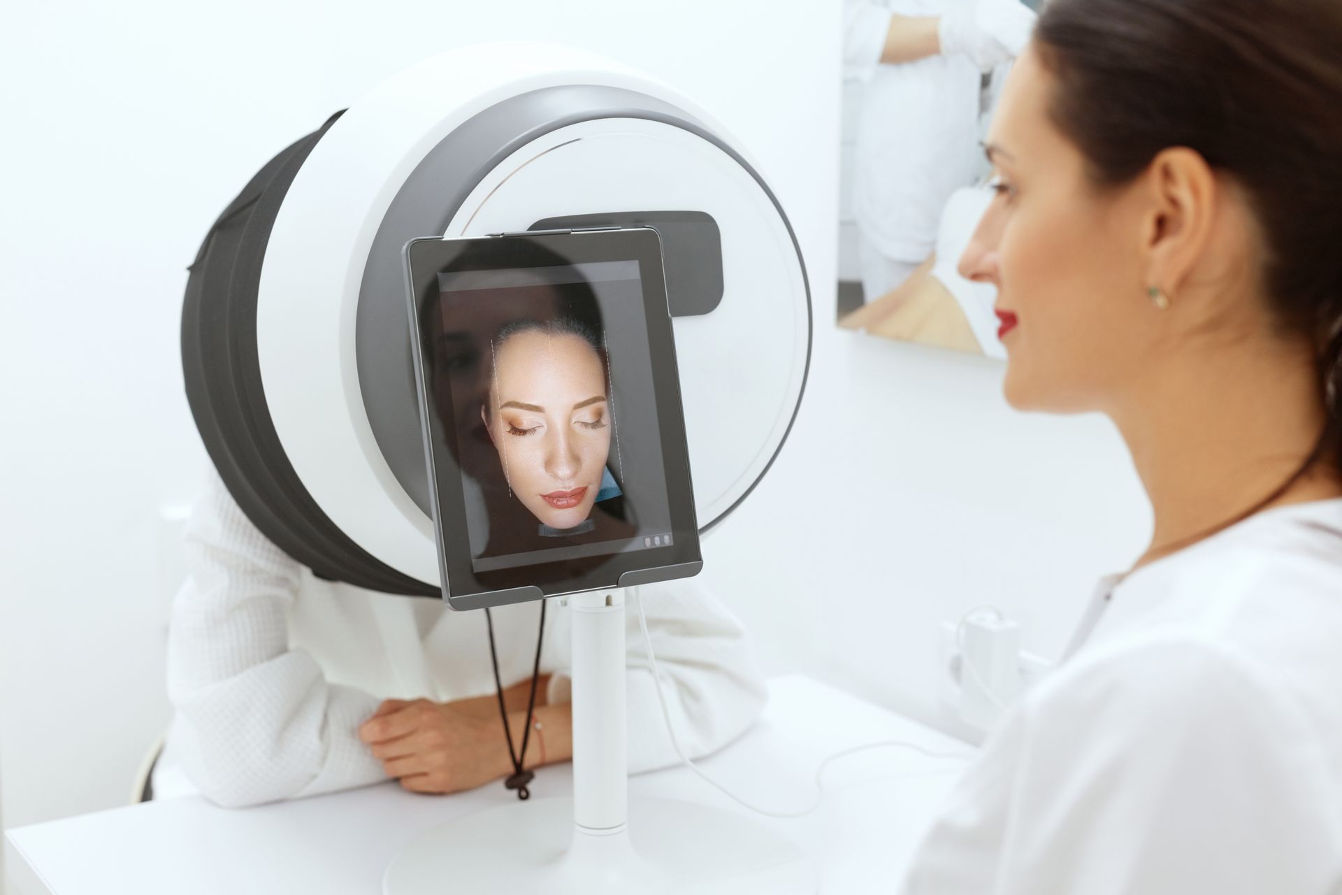 A woman is looking at her face on a tablet.