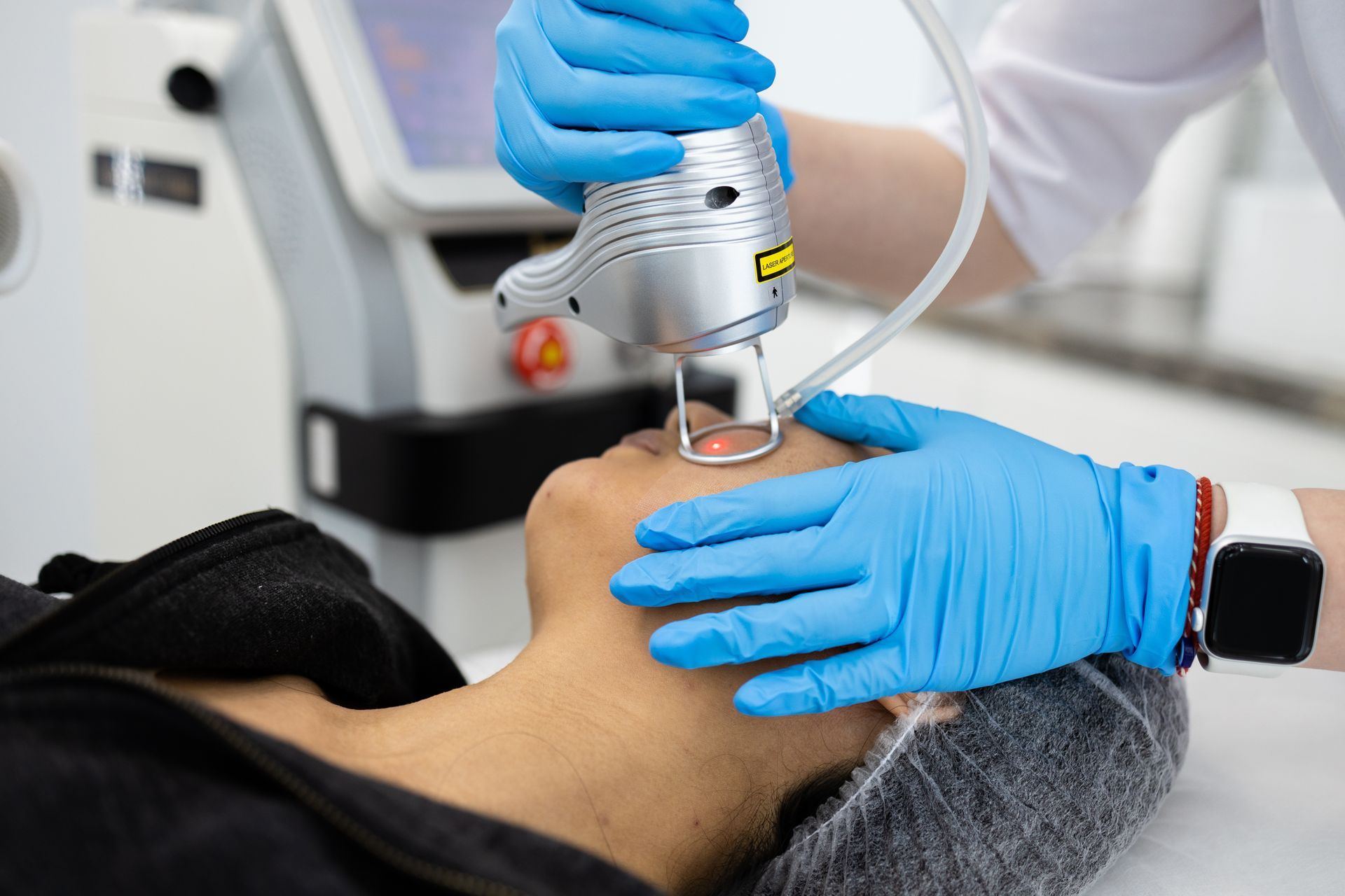 A woman is getting a laser treatment on her face.