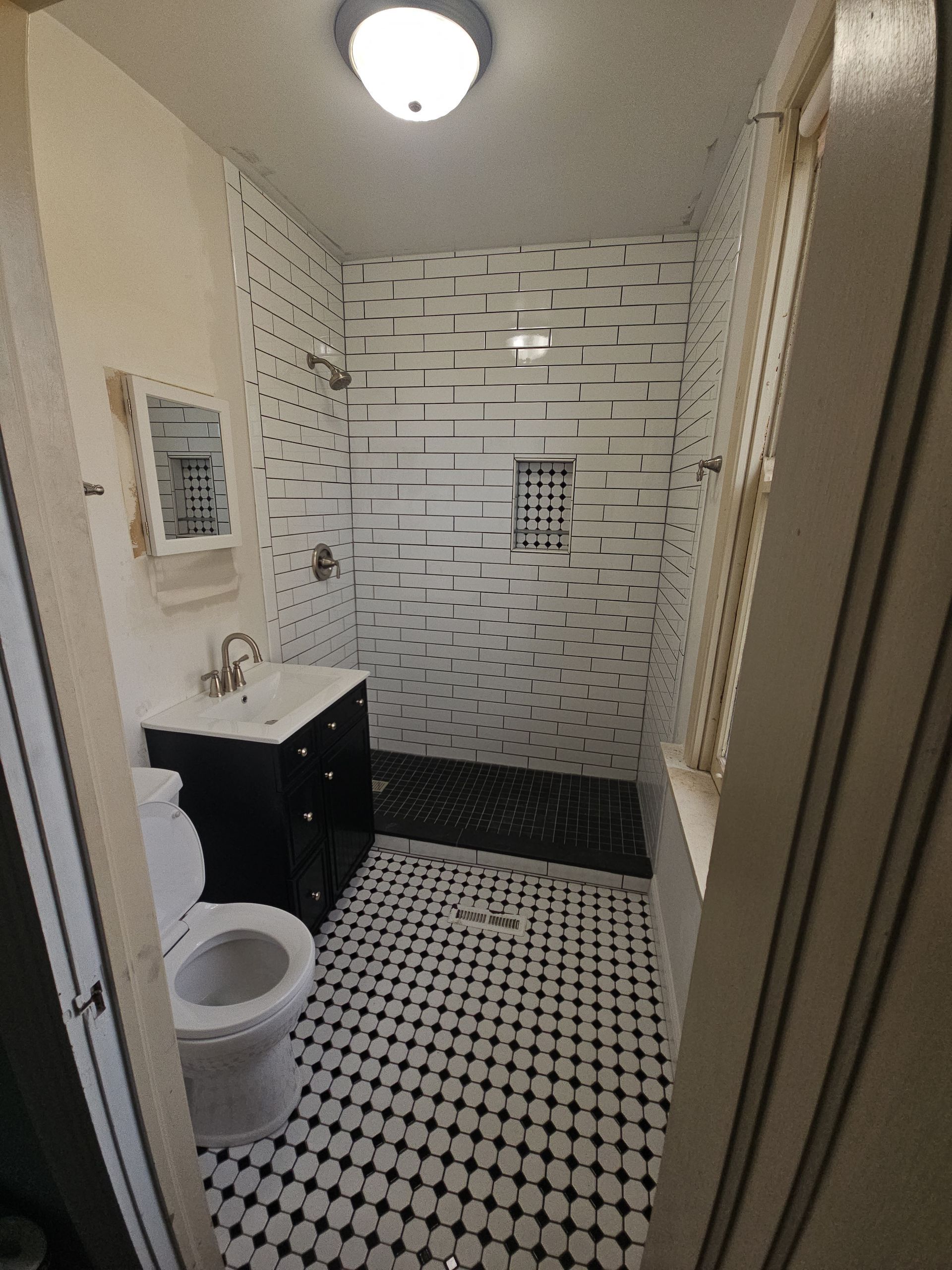 A bathroom with a toilet a sink and a shower