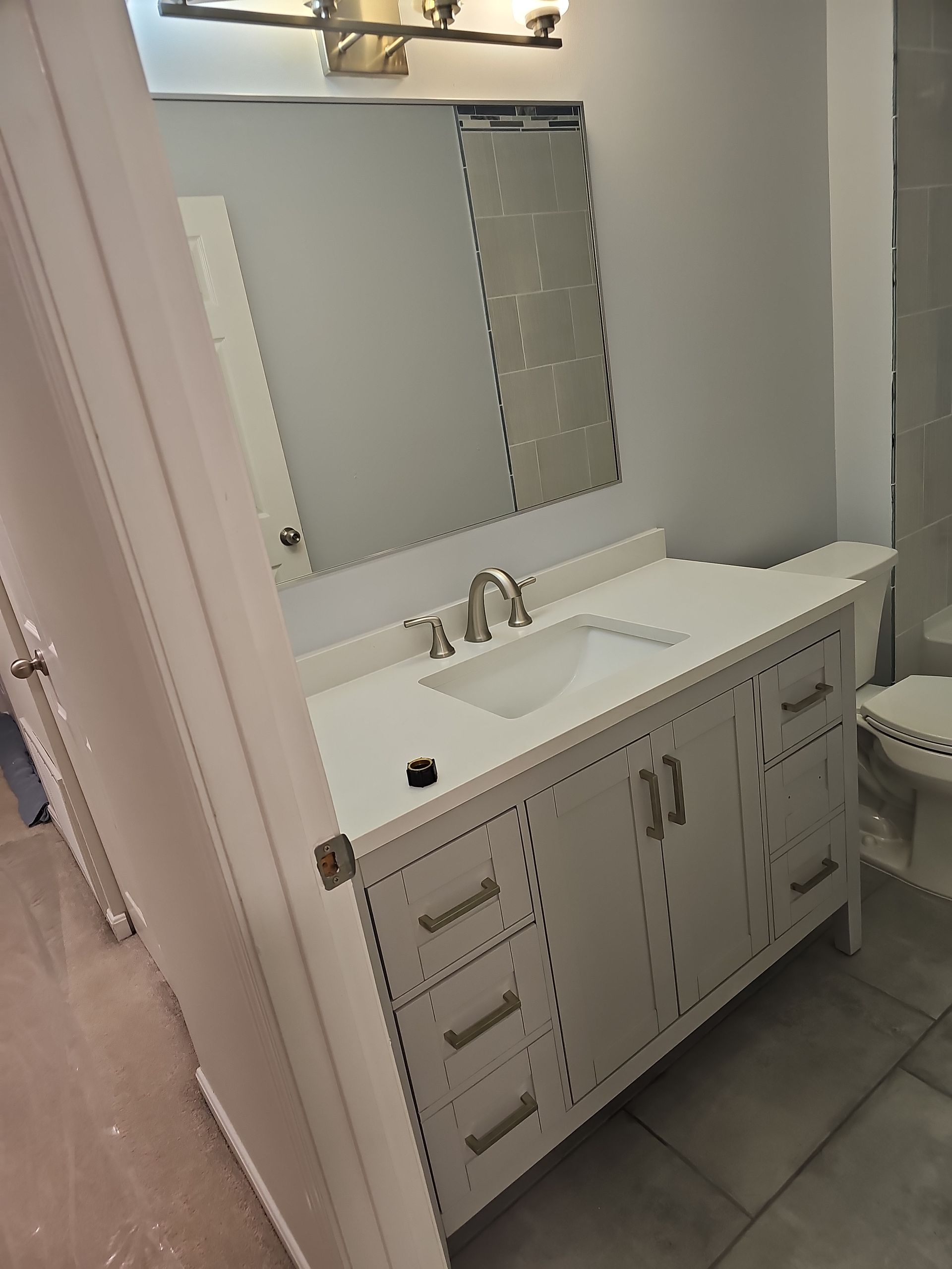 A bathroom with a sink , toilet and mirror.