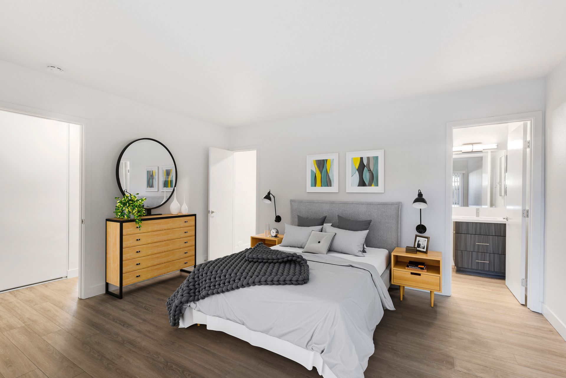 A bedroom with a bed , dresser , nightstand and mirror.