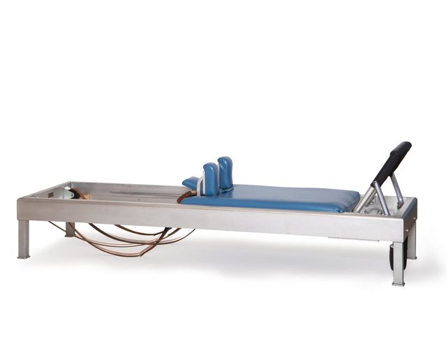 Pilates woman in cadillac acrobatic upside down balance reformer