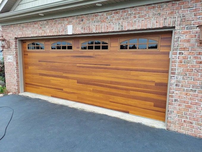 A wooden garage door is sitting on top of a brick building.