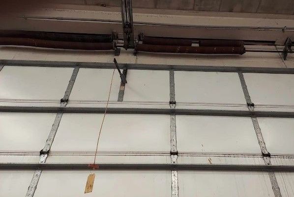 The inside of a garage door with a broken spring.