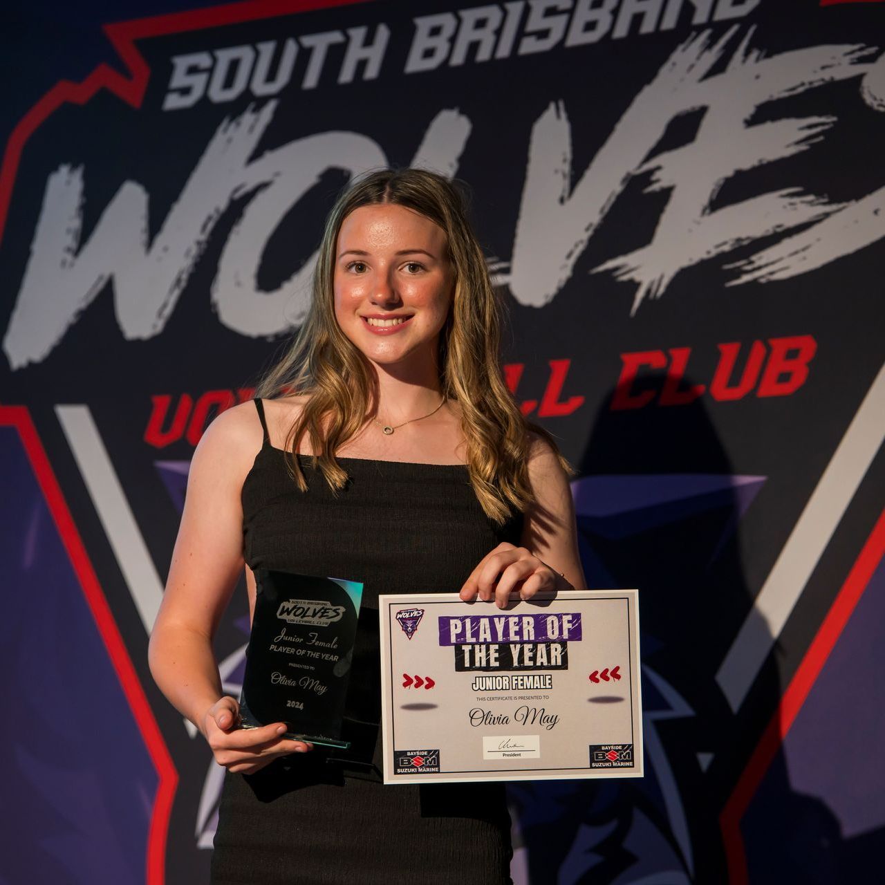 A woman holding a sign that says player of the year