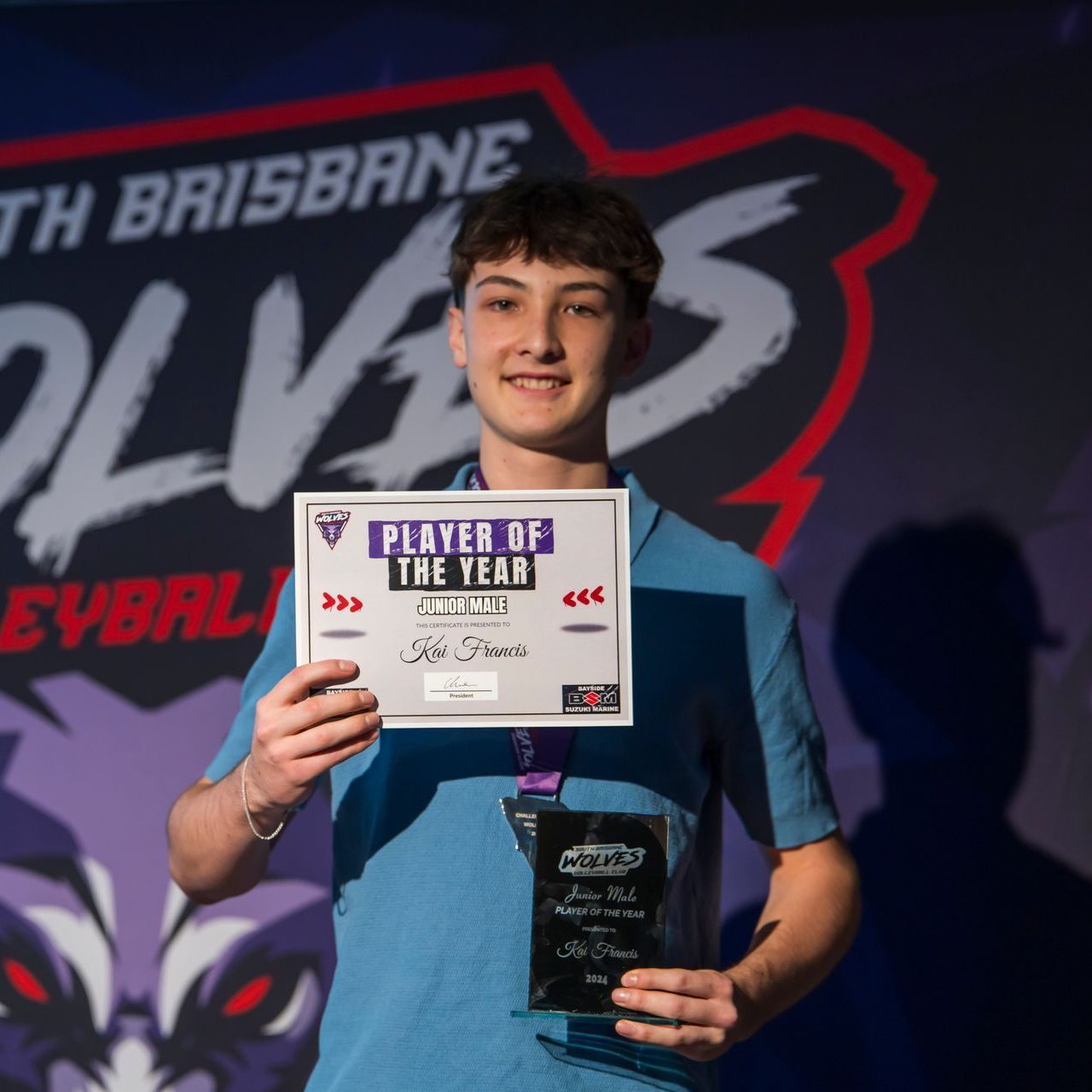 A young man is holding a sign that says player of the year
