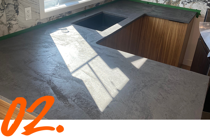 A kitchen counter with the number 02 in orange