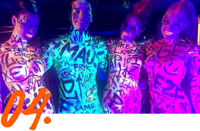 A group of people standing next to each other with their bodies painted with graffiti