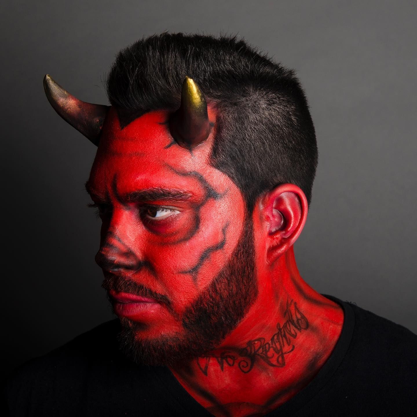 Un homme avec du maquillage rouge et des cornes sur la tête.