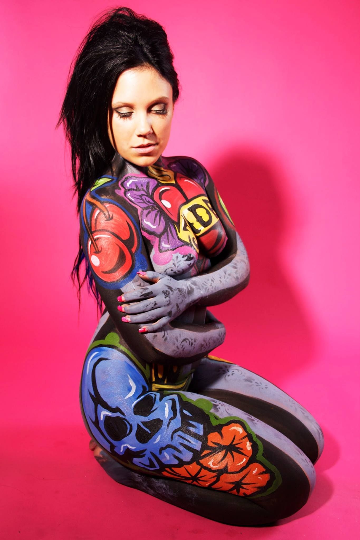 Une femme est agenouillée avec son corps peint.