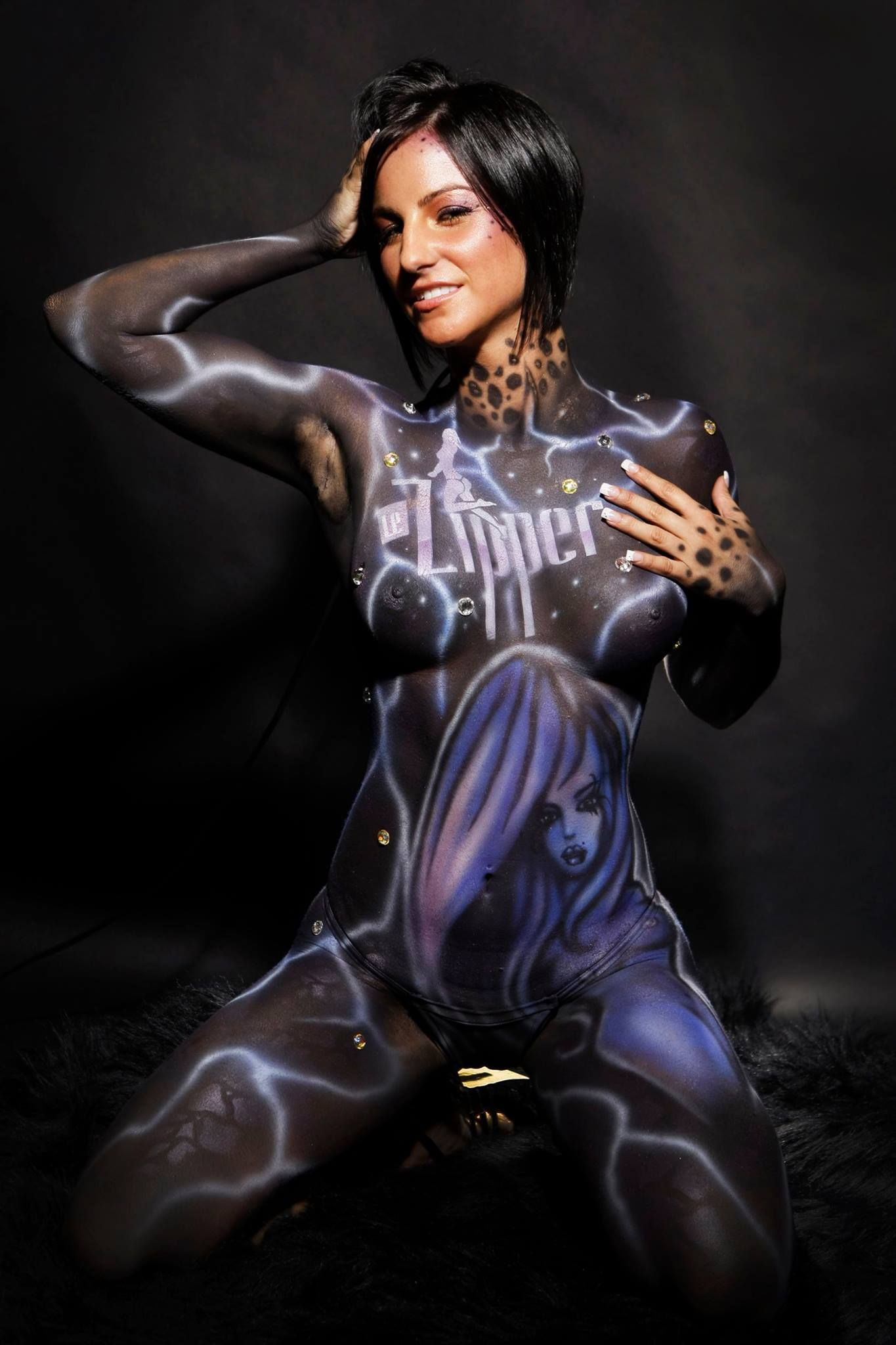 Une femme est agenouillée avec son corps peint.