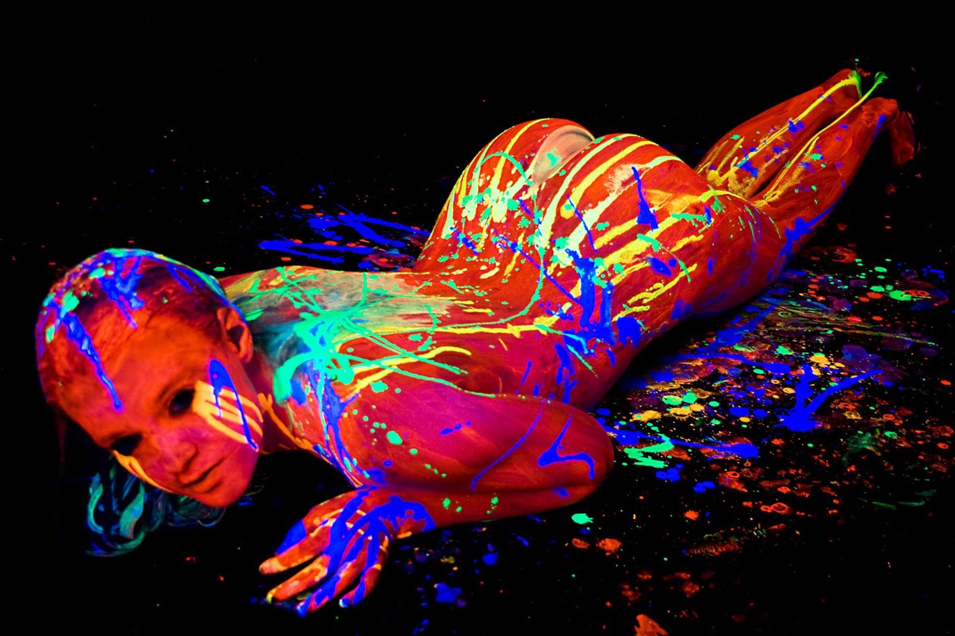 Une femme est recouverte de peinture phosphorescente.