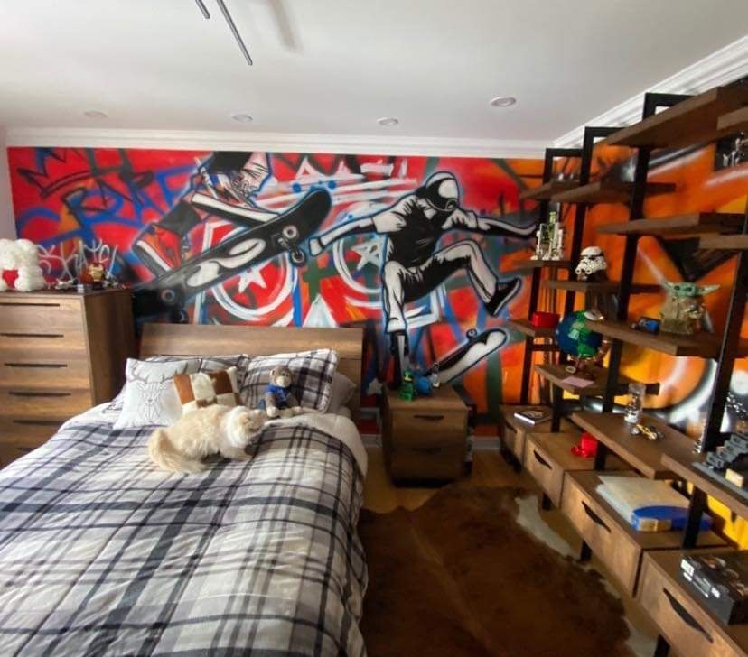 Une chambre avec une peinture murale sur le mur et un lit