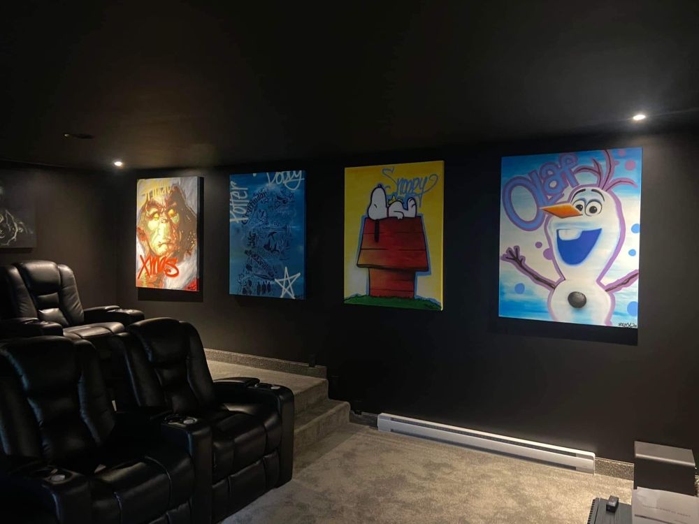 Un home cinéma avec des peintures de Snoopy et Olaf sur le mur.