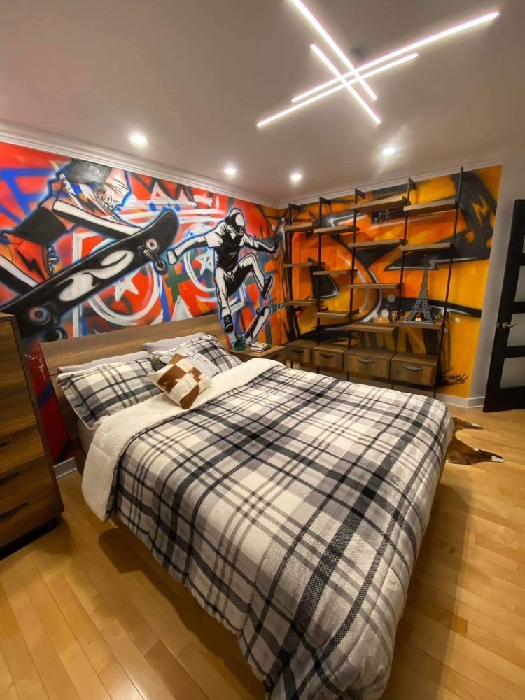 Une chambre avec un lit et une peinture murale sur le mur.