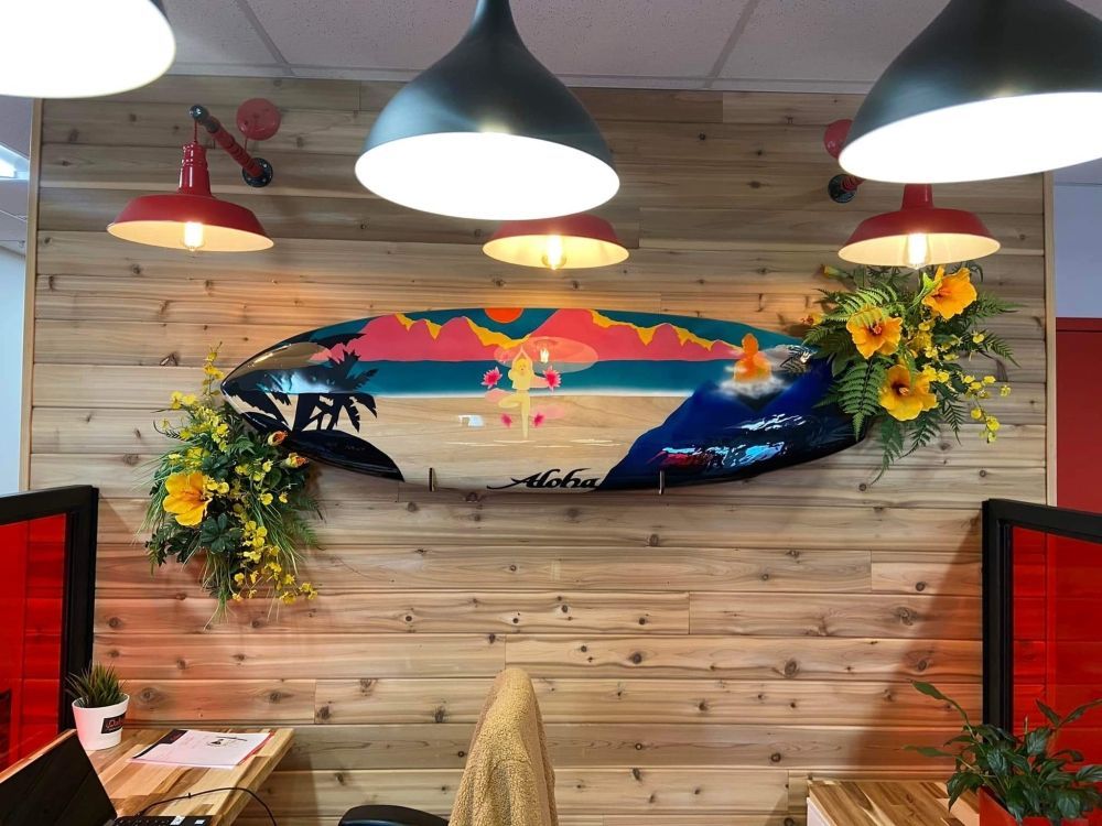 Un mur en bois avec une peinture représentant une planche de surf dessus.