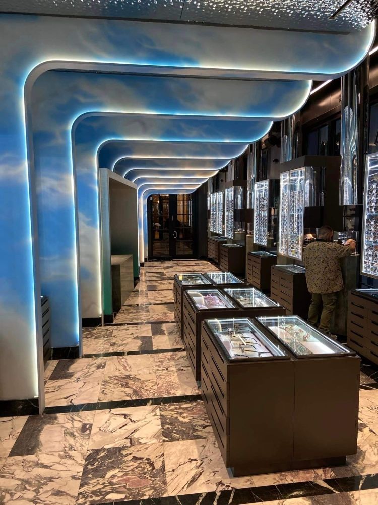 Un long couloir avec un ciel bleu peint au plafond.