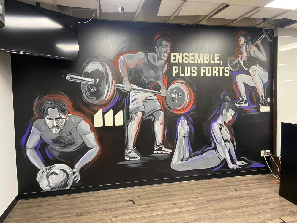 Une peinture murale d'un homme soulevant une barre et d'une femme faisant des pompes sur un mur.