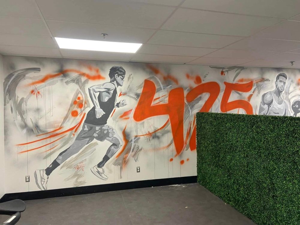 Un mur avec une peinture d'un homme qui court et le numéro 425 dessus.