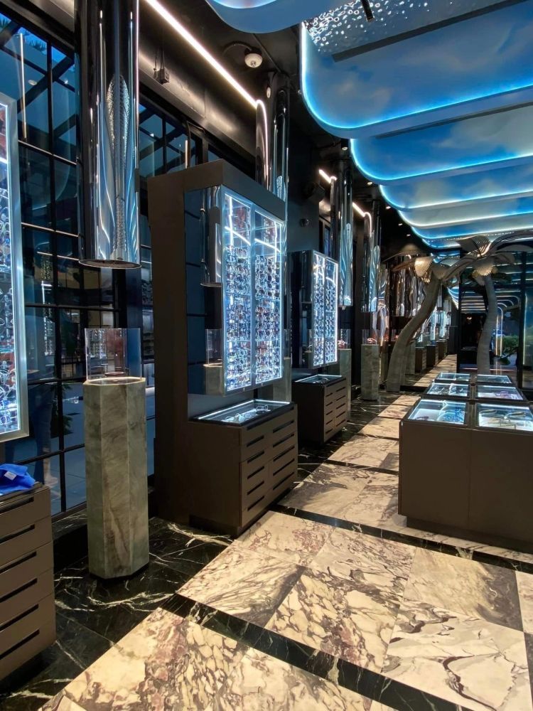 Un long couloir avec un sol en marbre et de nombreux présentoirs dans un magasin.