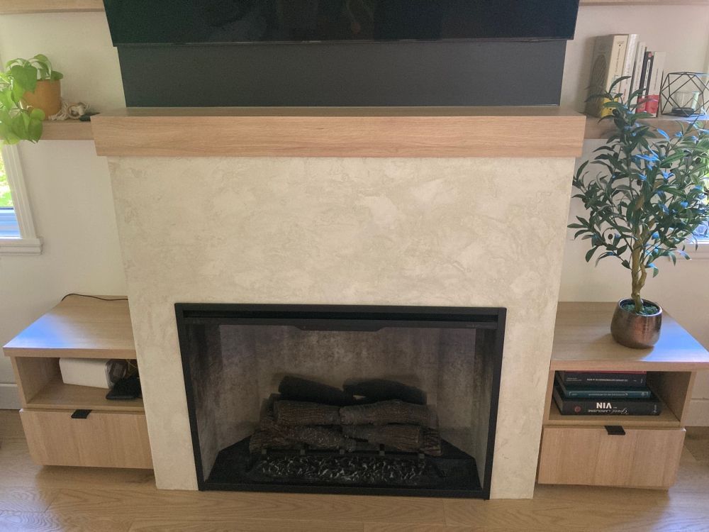 Une cheminée dans un salon avec une plante devant.