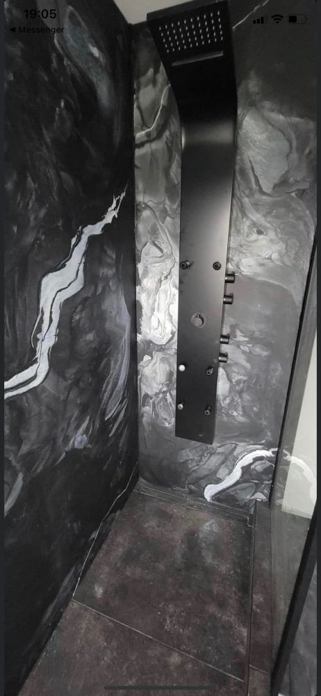 Une photo en noir et blanc d'une douche avec une pomme de douche noire.