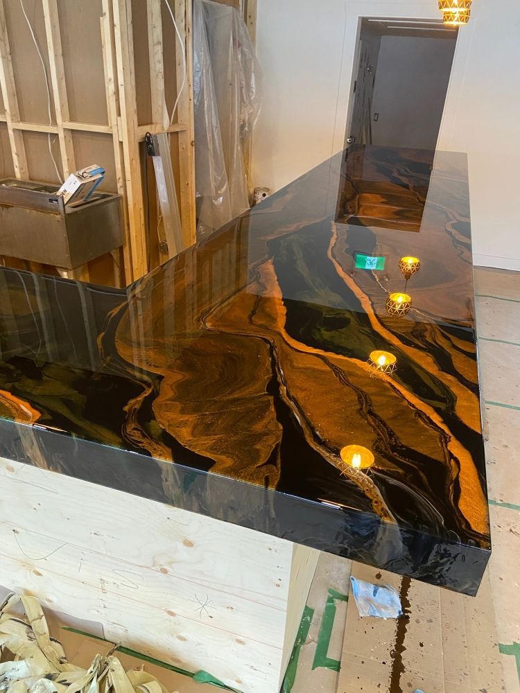 Un comptoir noir et or est posé sur un plancher en bois dans une pièce.