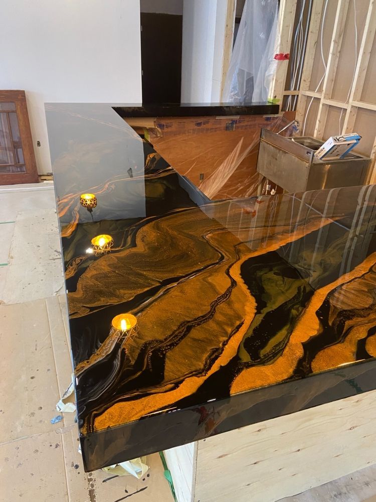 Un comptoir noir et or avec des bougies dessus dans une pièce.